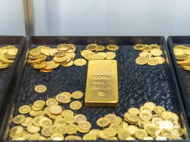 Gold coins surround a gold bar.
