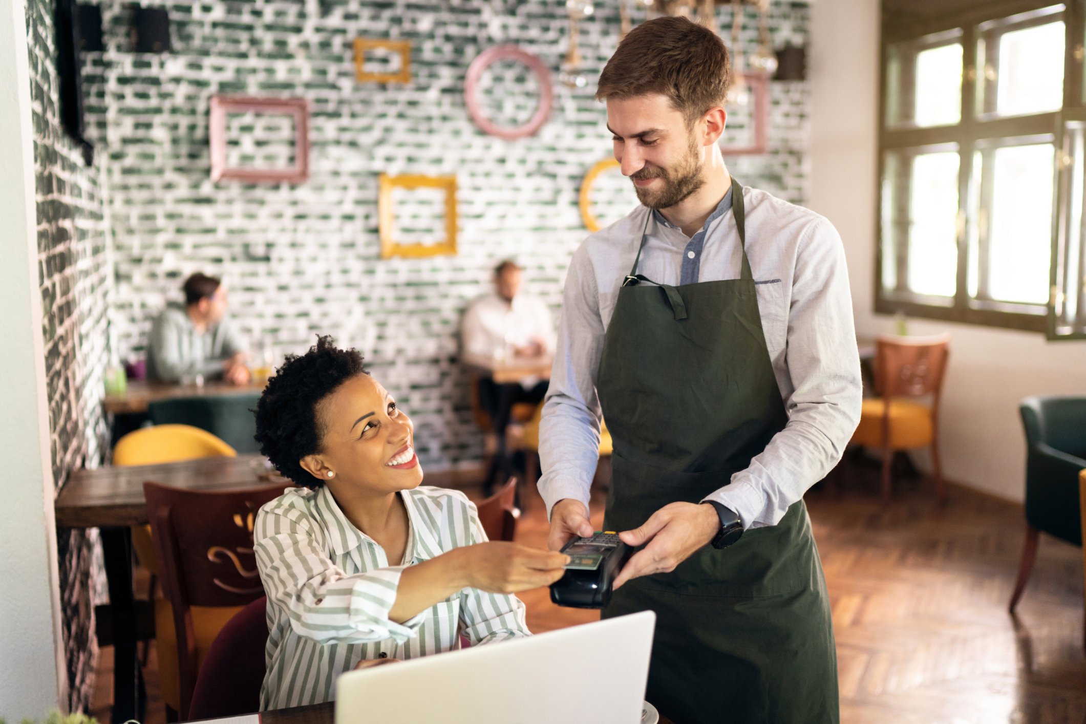 Person swiping card at a coffee shop.