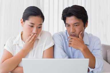 Worried Asian couple, laptop
