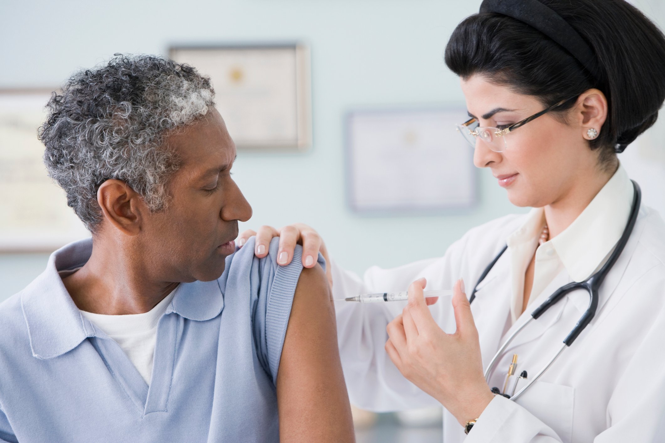 A doctor vaccinates a patient in a clinic.