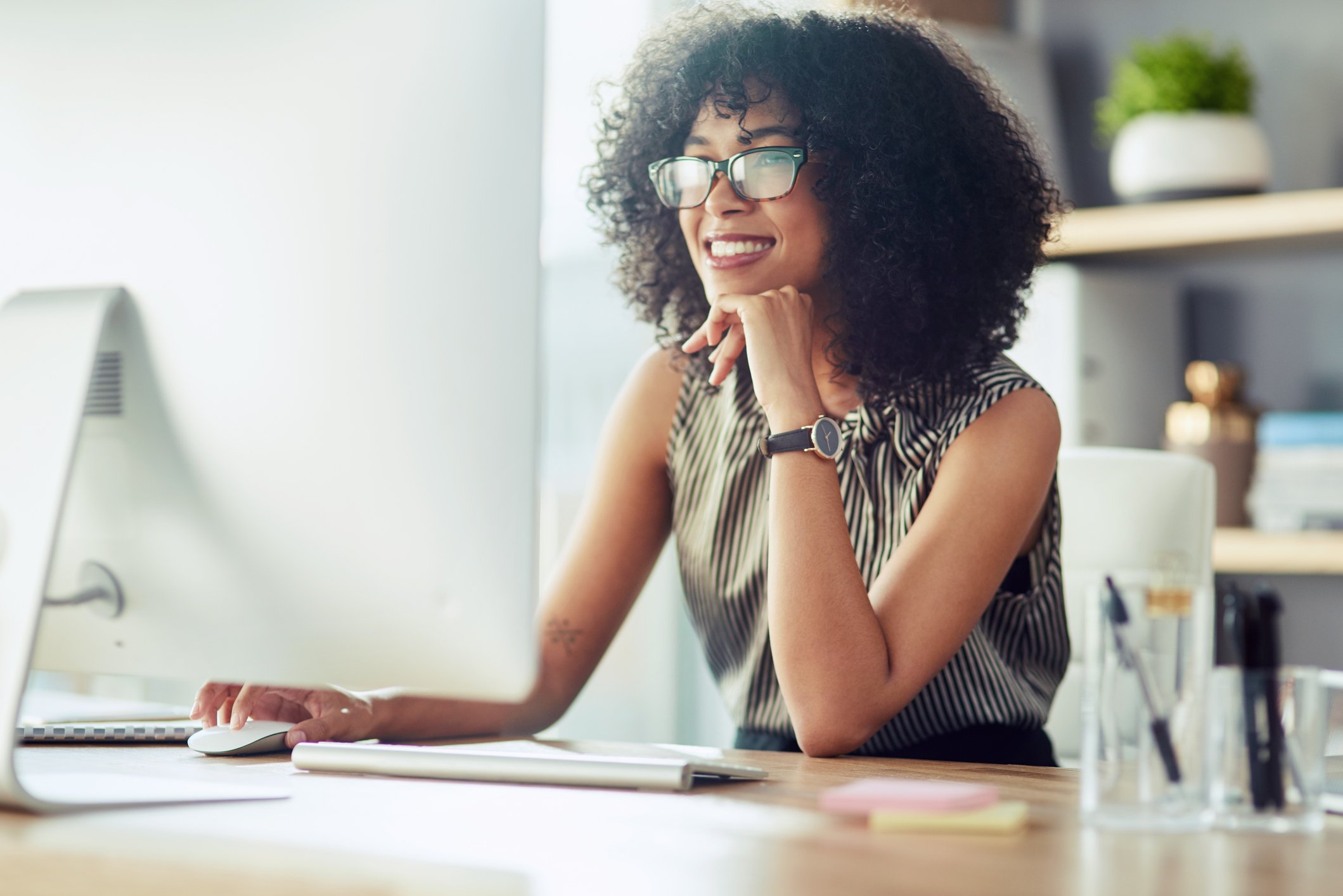 Person at a desk using a PC and looking pleased.