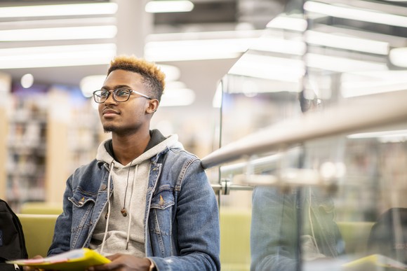 A student listens to a lecture in a library. 