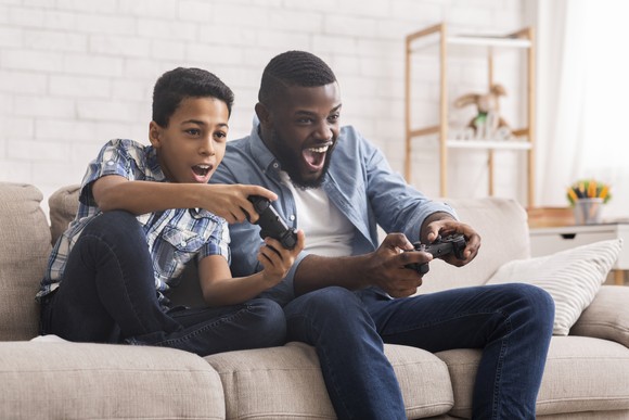 An adult and a child playing video games.