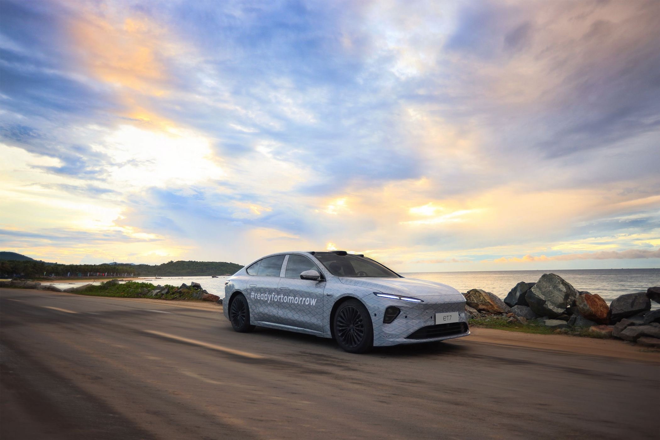 Nio ET7 sedan driving by water. 