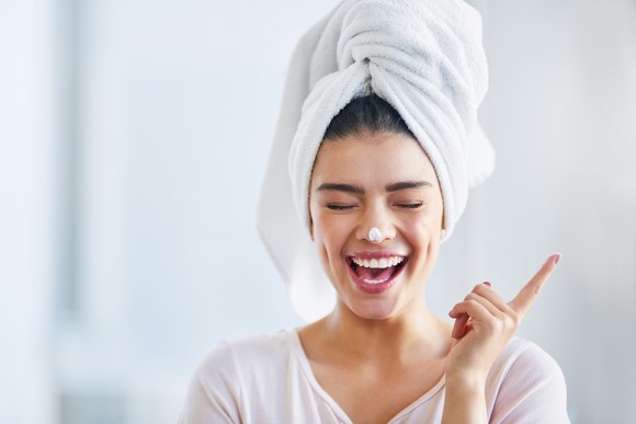 Happy person applying a skincare product.