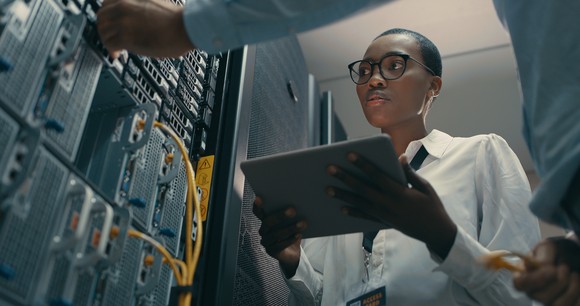 An IT worker checks security protocols in a data center.