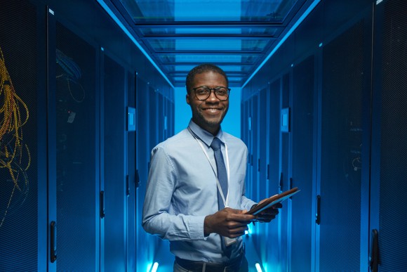 Technology worker standing in a data center.