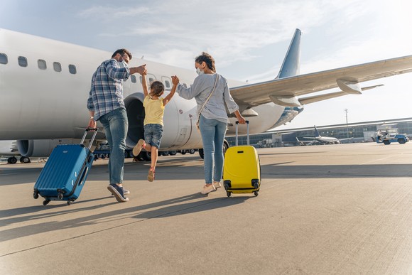 Three people going to board an airplane.