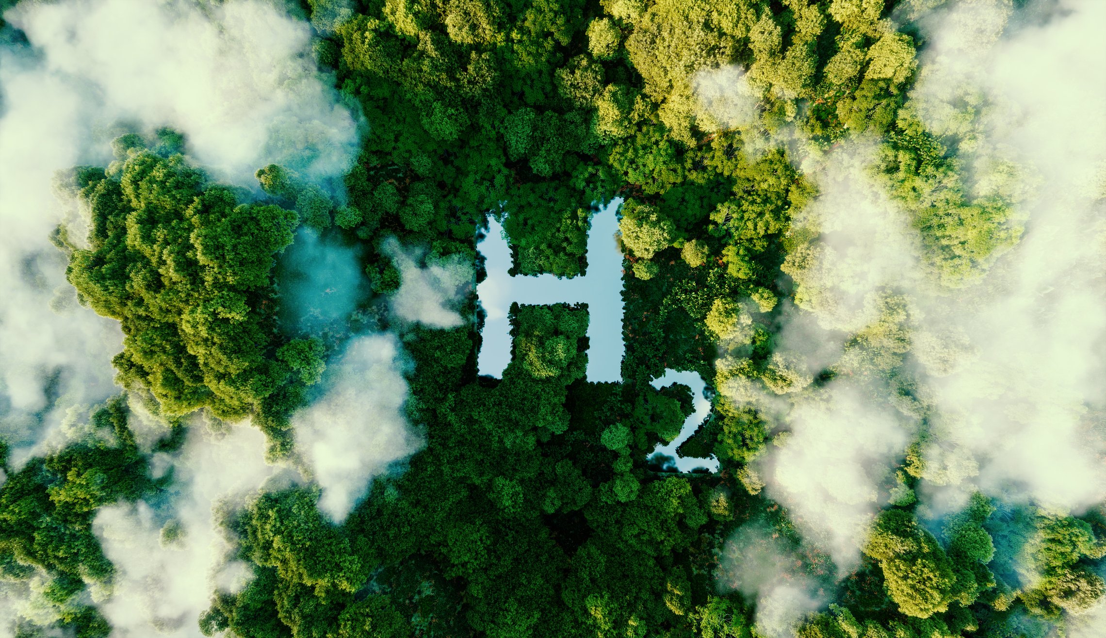 View of forest from above, with a lake in the shape of H2.