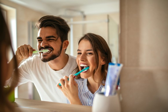 Two people brushing their teeth.