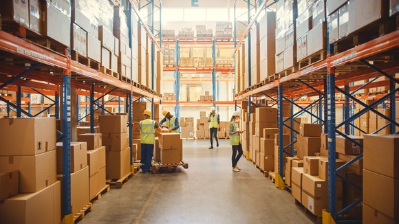 A large warehouse with employees moving boxes of inventory.
