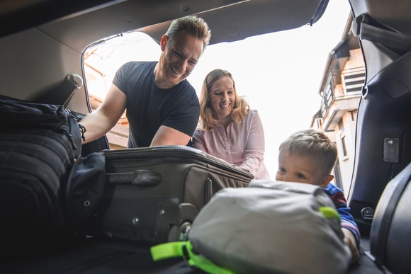 Family packing their car with luggage.