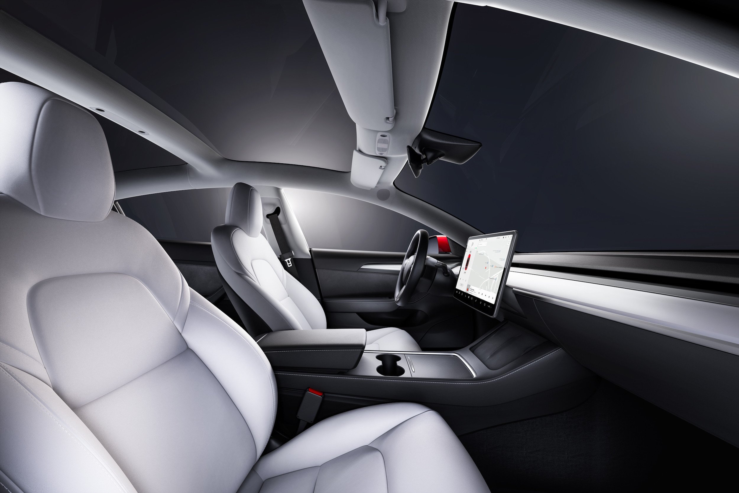 Interior of a Tesla Model 3, showing the front passenger's and driver's seats from a side view.
