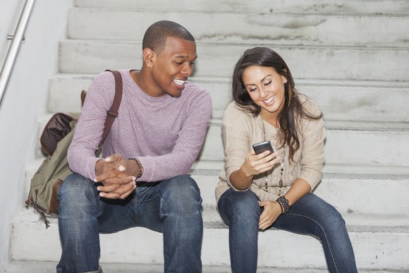 Two people looking at a phone.