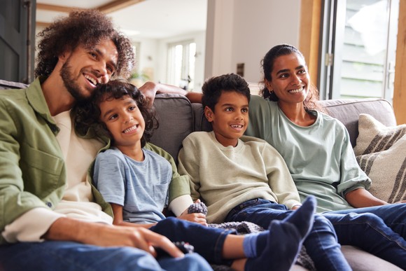 Family watching TV in their living room. 