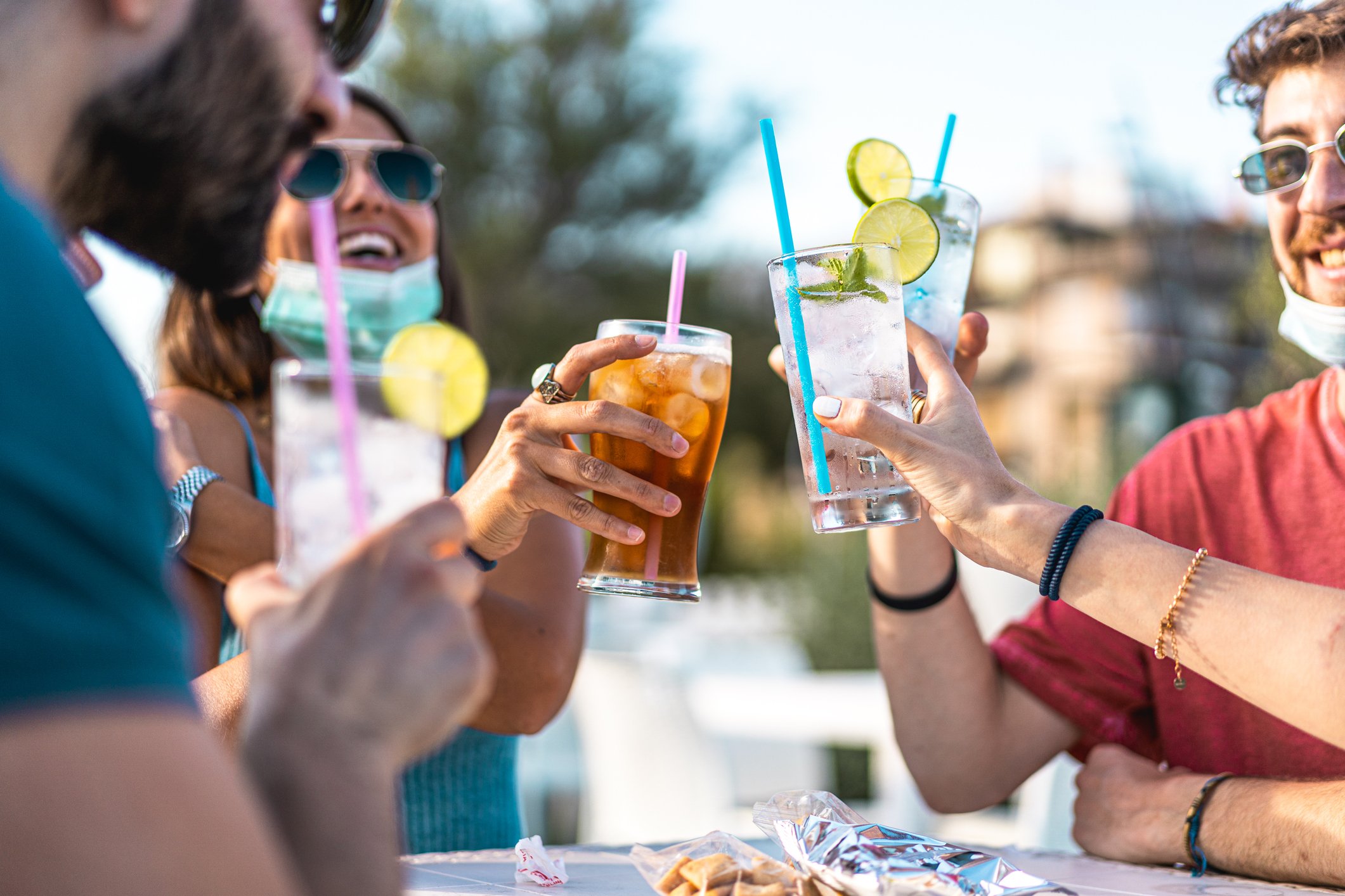 Four friends drinking together outside.