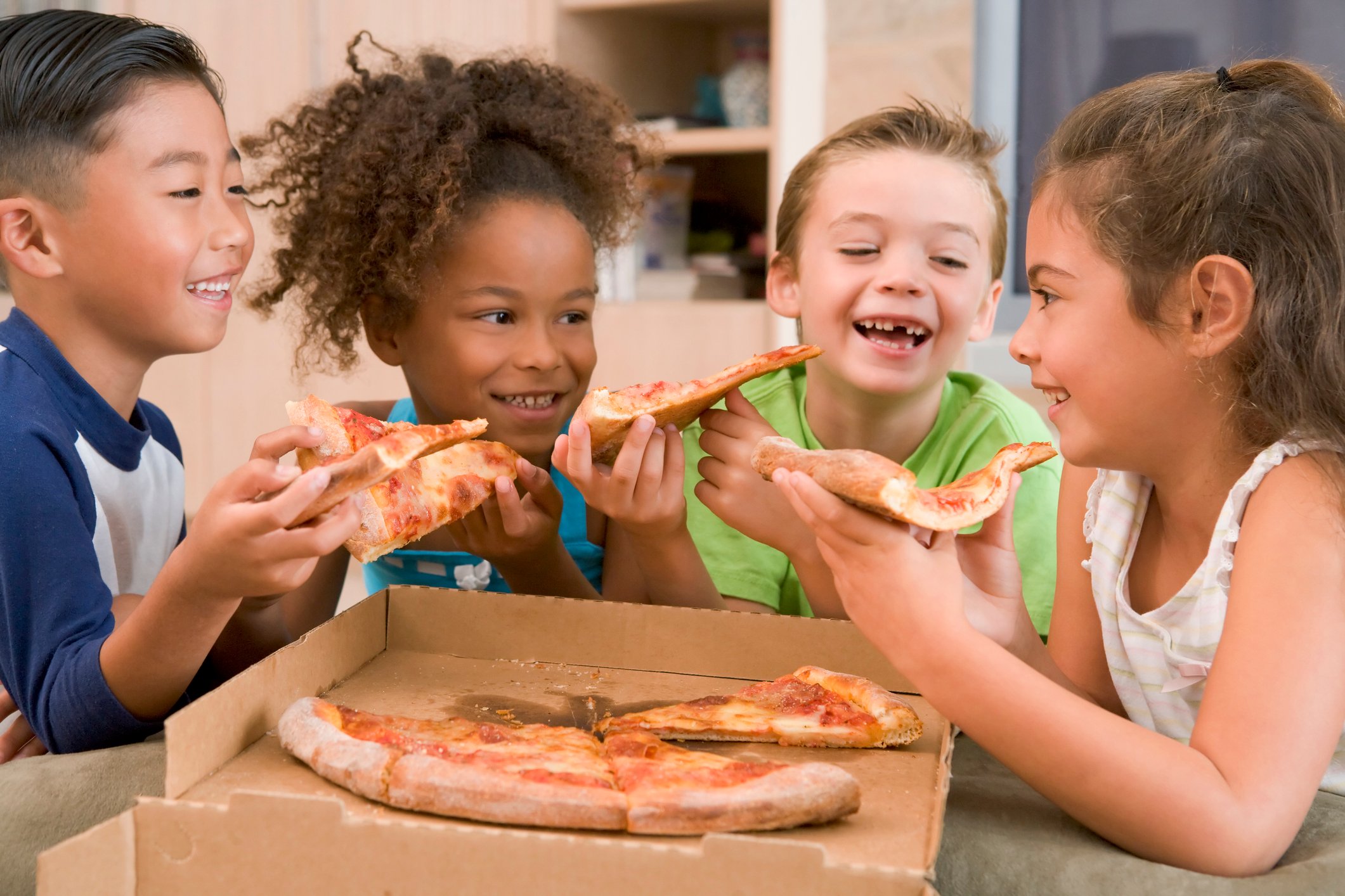 A group of children eating pizza.