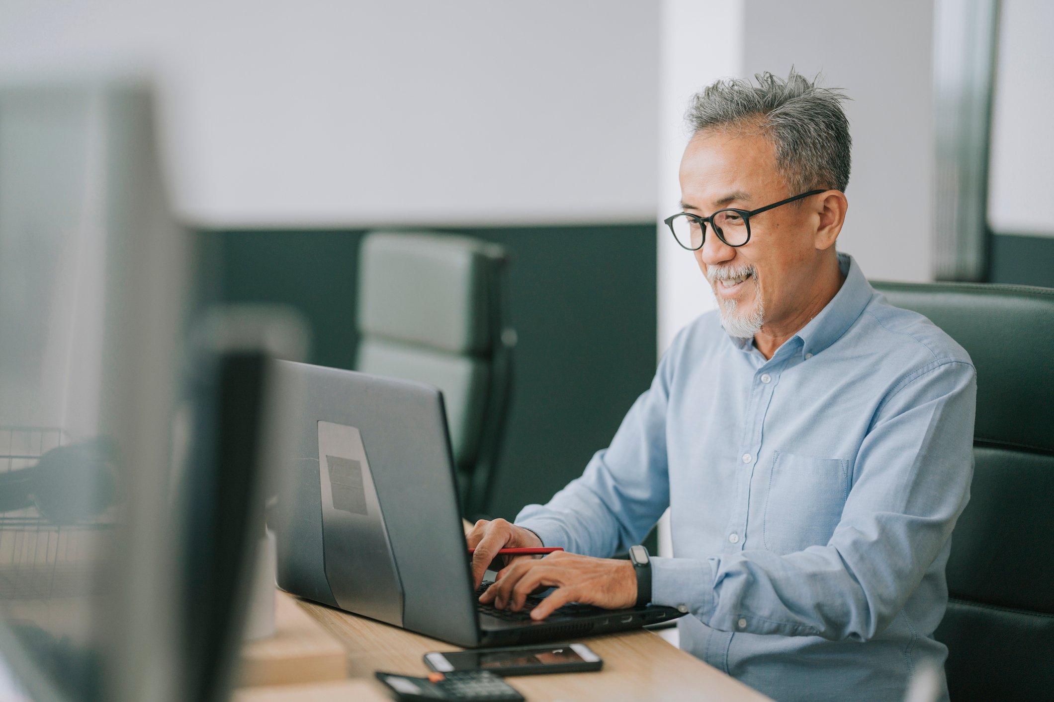 A person sits at a desk and uses a computer.