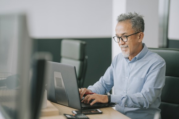 A person sits at a desk and uses a computer.