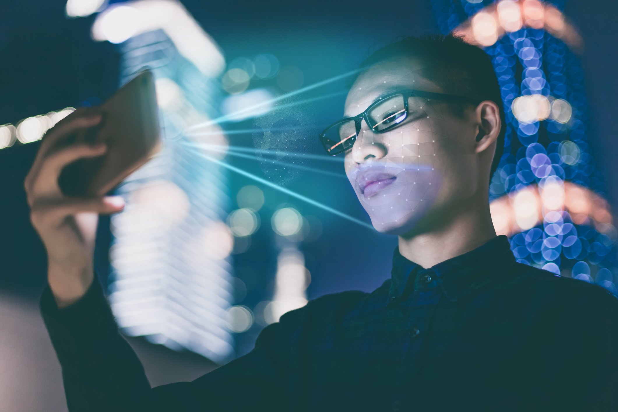 A person uses a smartphone to scan their face. 