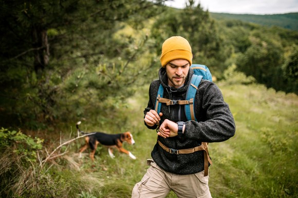 A hiker checks his watch.