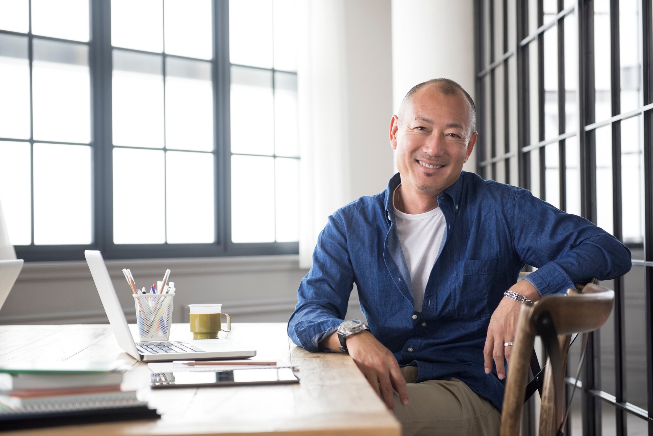 A smiling person at a desk.