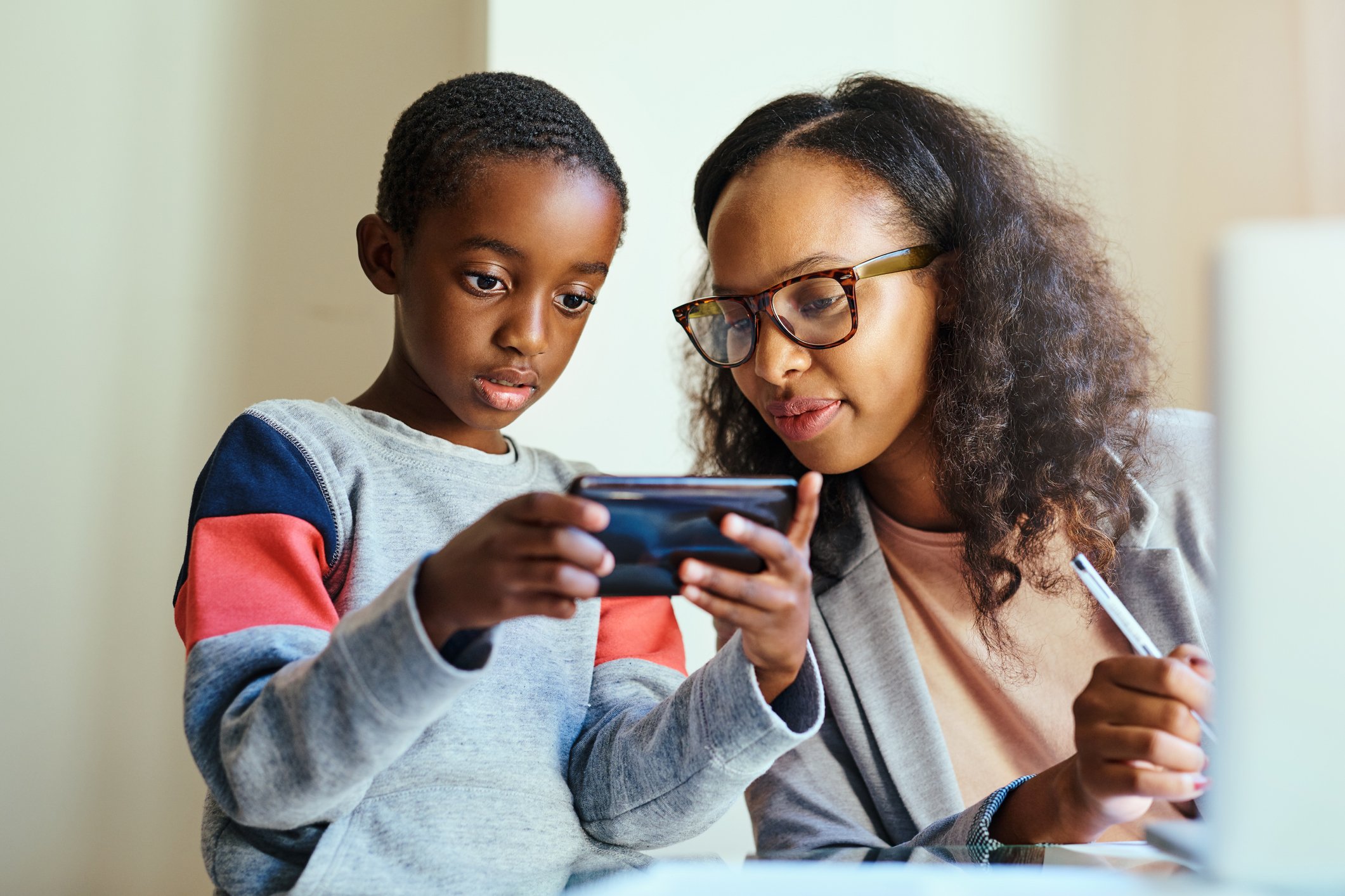 A mother and her son using a smartphone.