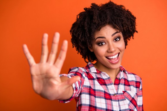 Woman holding up five fingers