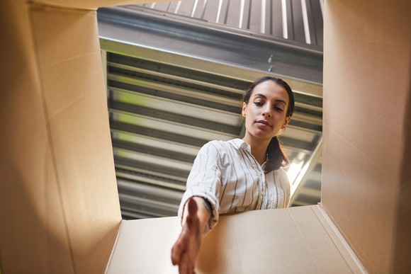 A person reaching into a box in a self-storage unit.