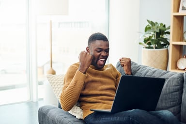 Cheering African American man, laptop