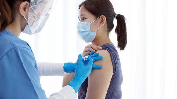 A healthcare professional giving a vaccine shot to a person.