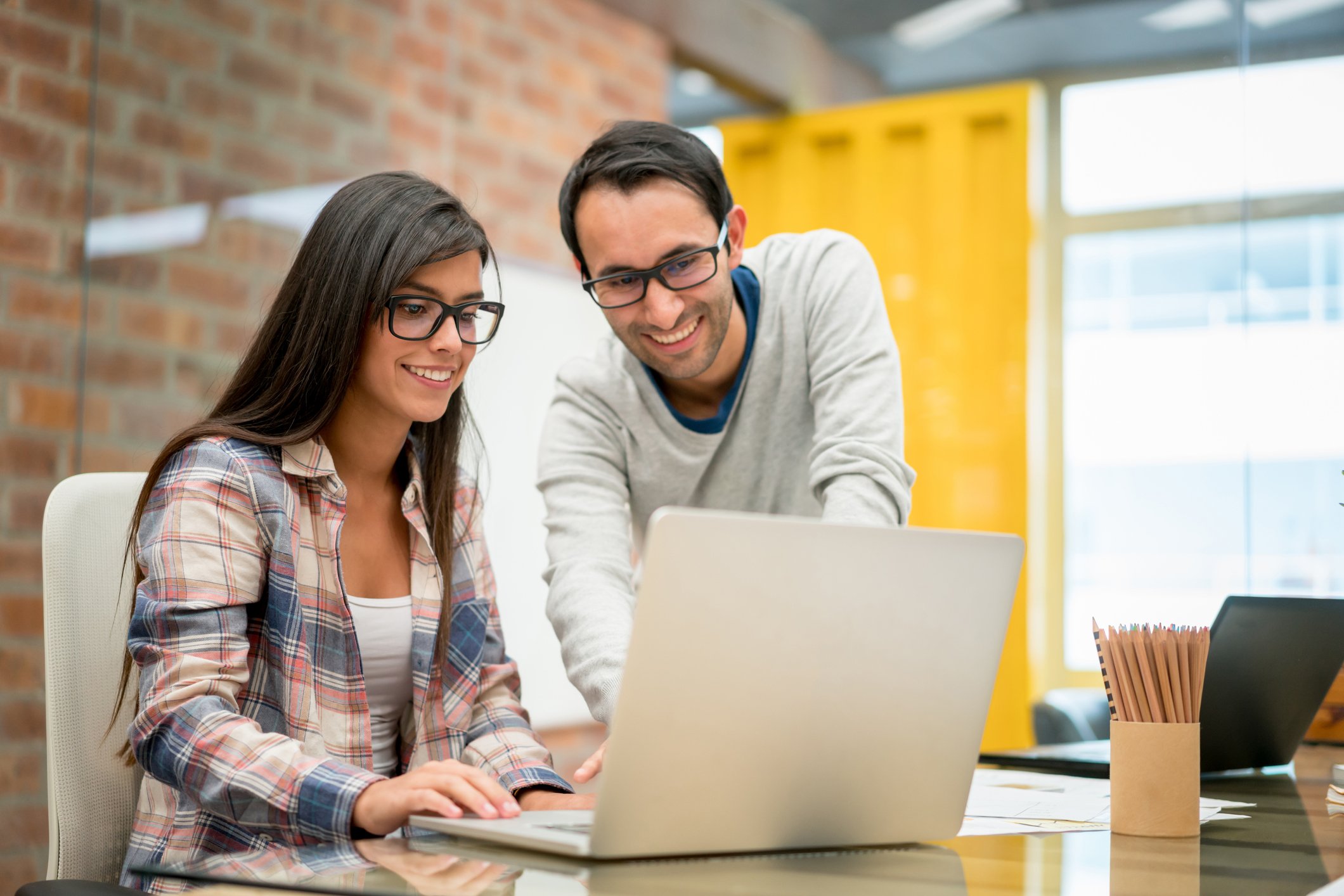 Two people looking at laptop together and smiling.