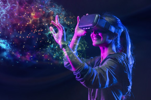 A girl wearing a virtual reality headset engages with a nebulous cloud of color.