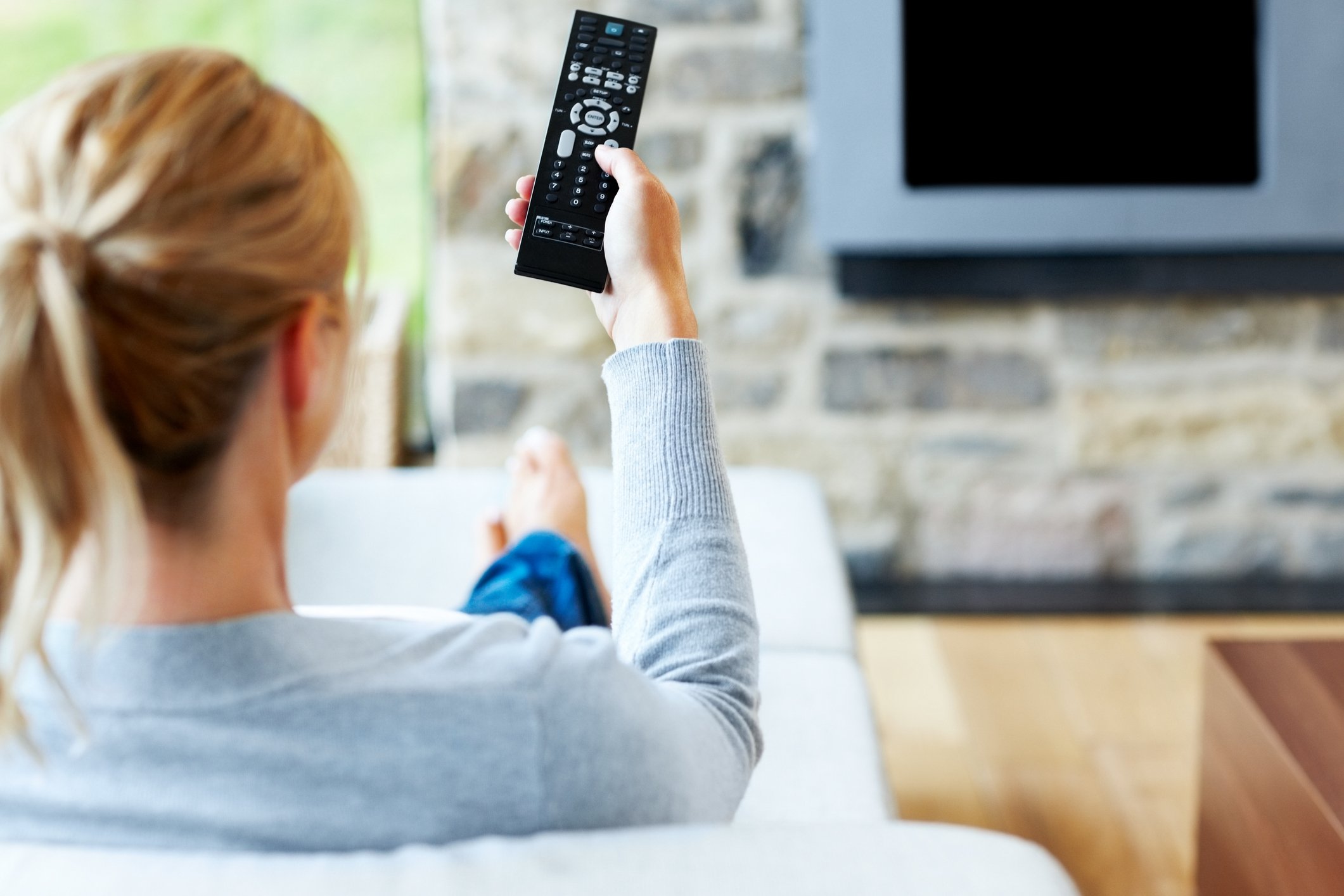 A person holding a TV remote.