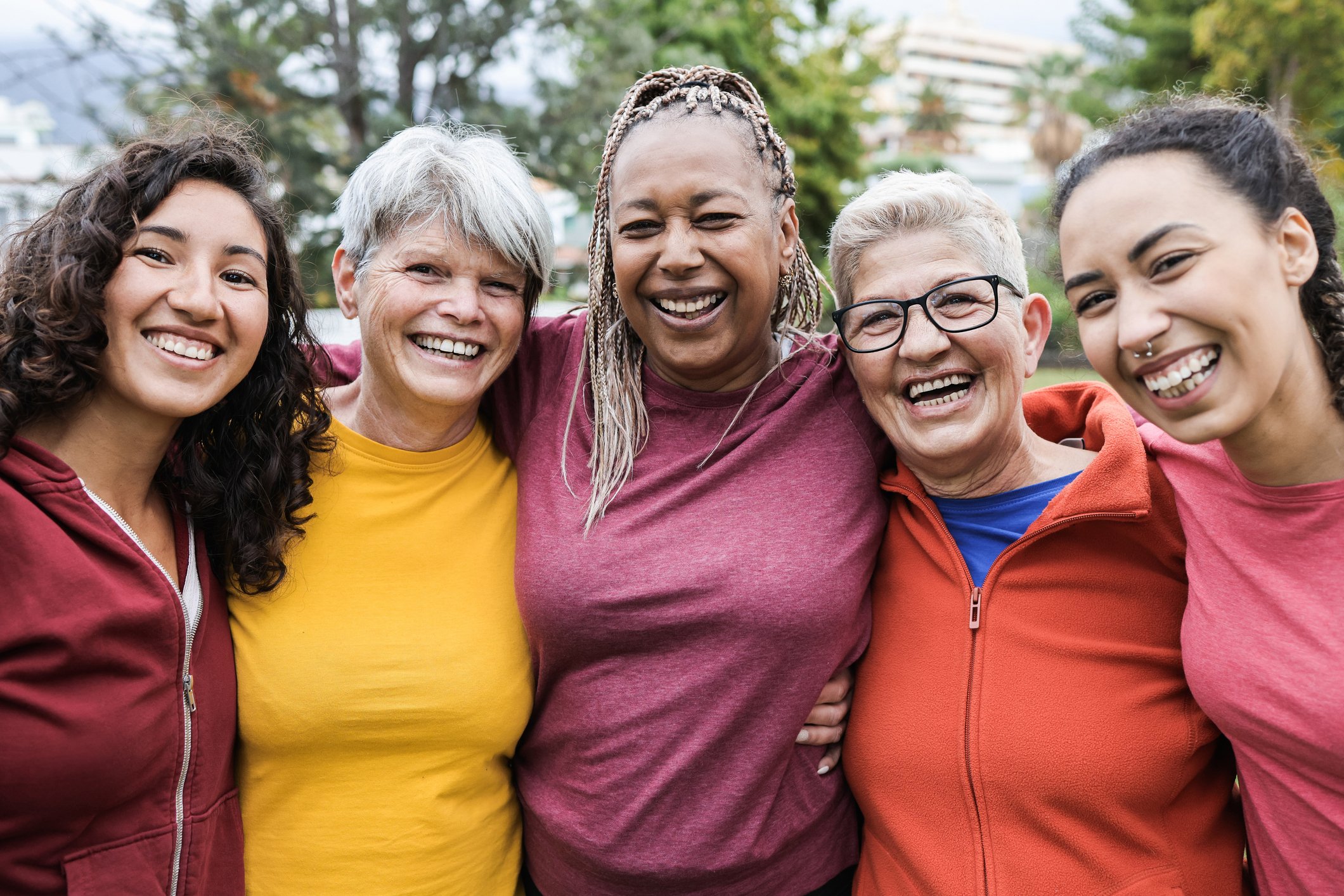 A group of friends smiling while standing outdoors.