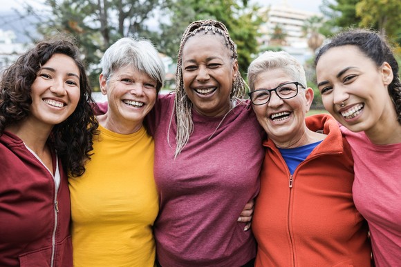 A group of friends smiling while standing outdoors.
