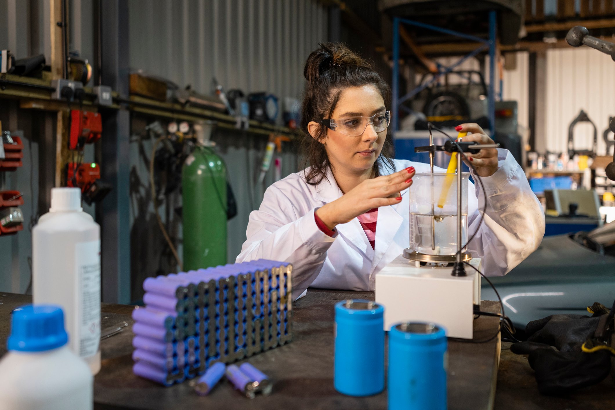 Scientist working on lithium recycling with equipment on a table in a prefabricated building.