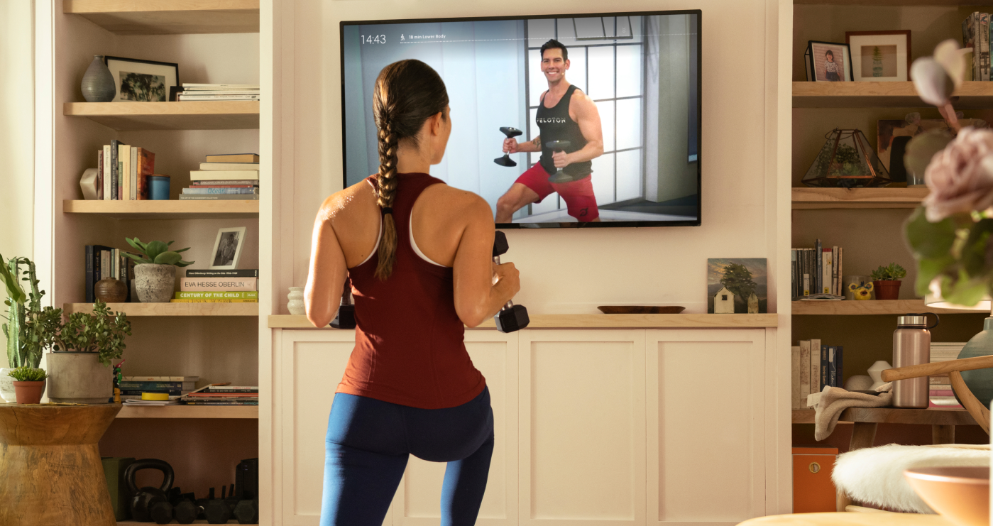 Woman exercising in front of a TV.