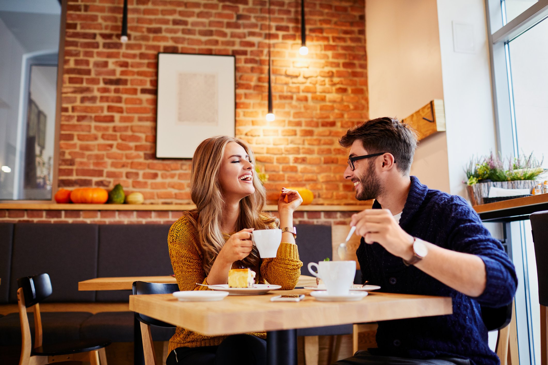 Two people drink coffee at a cafe.