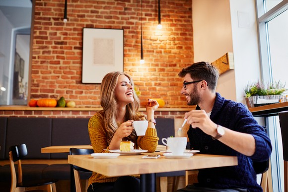 Two people drink coffee at a cafe.
