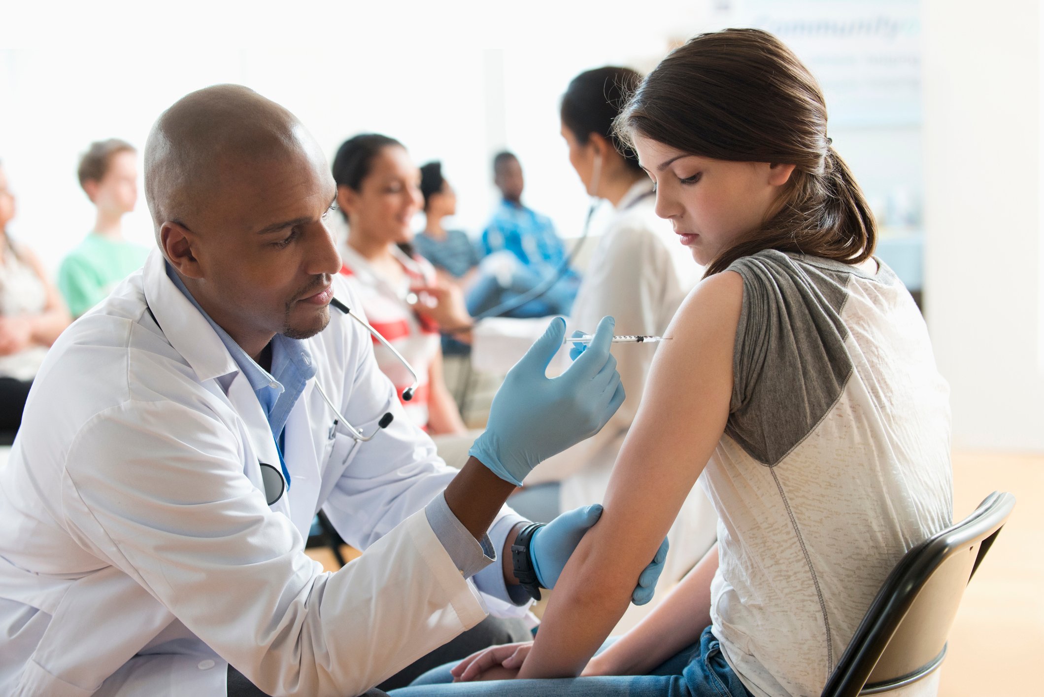 A healthcare professional is administering a vaccine to a patient. 