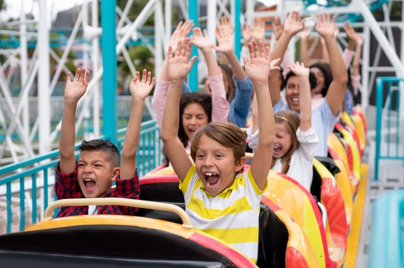 A group of people on a ride with their hands up in the air.