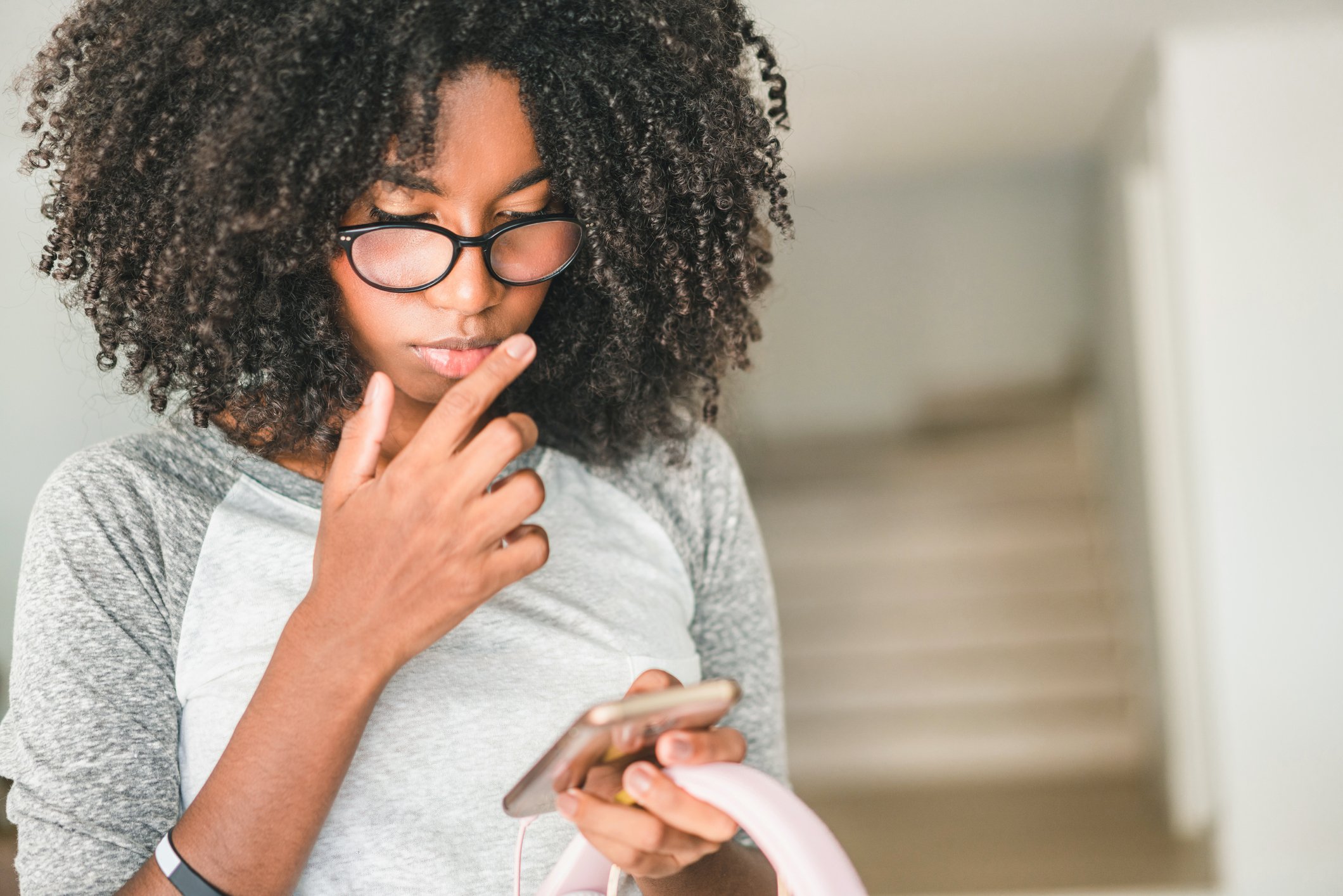 Young woman looks worried at her phone. 