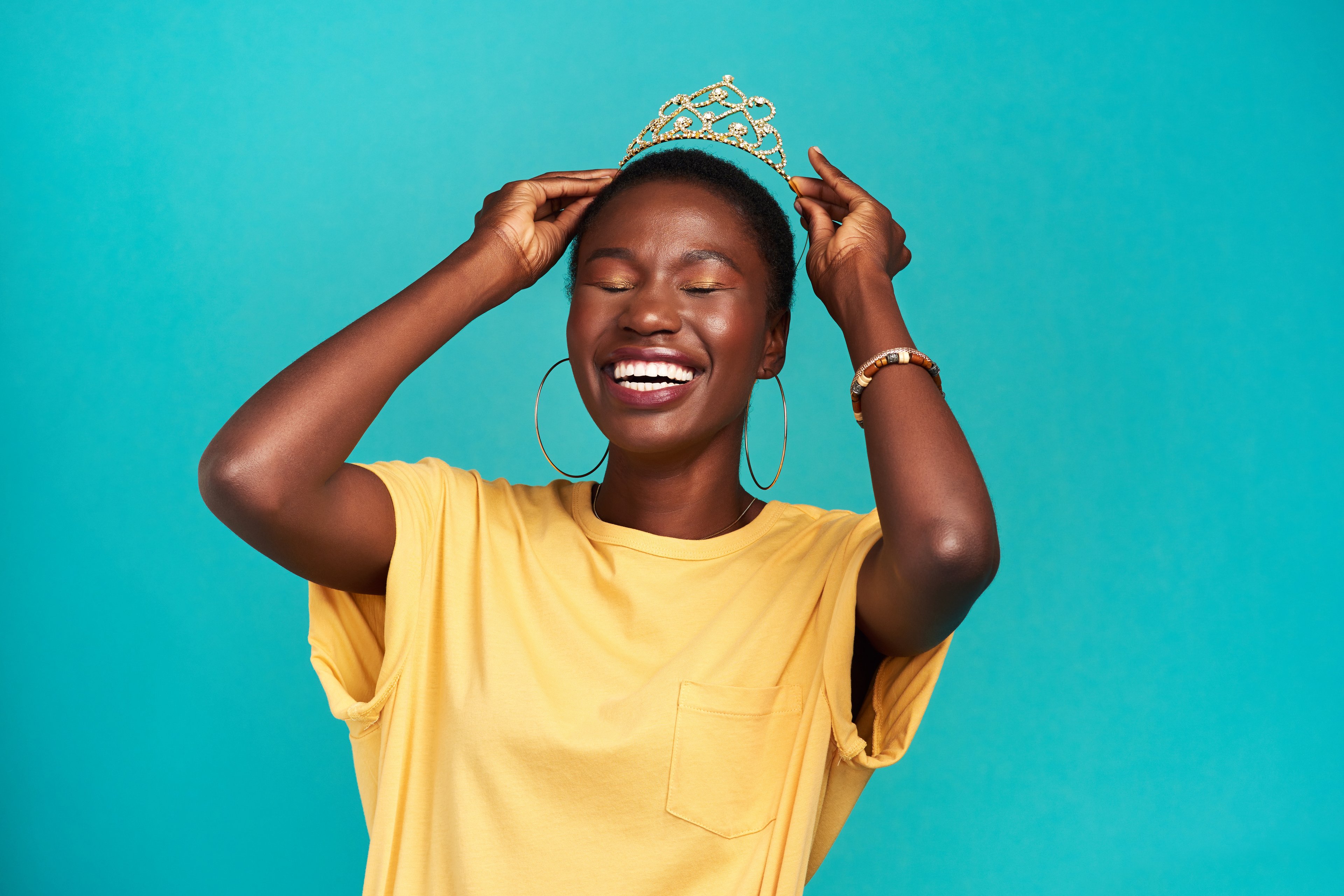 A person laughing and put a crown on their head. 
