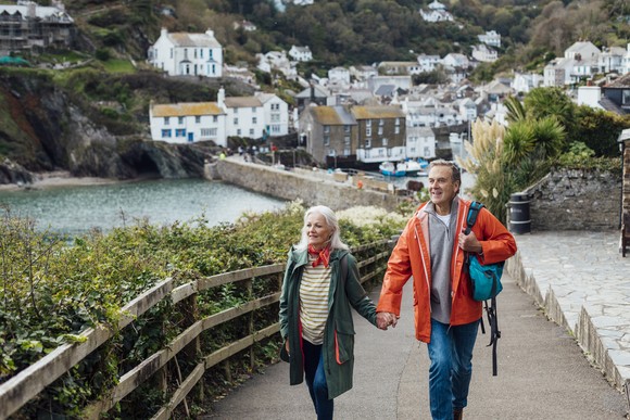 Two happy people taking a stroll while dressed in light jackets.