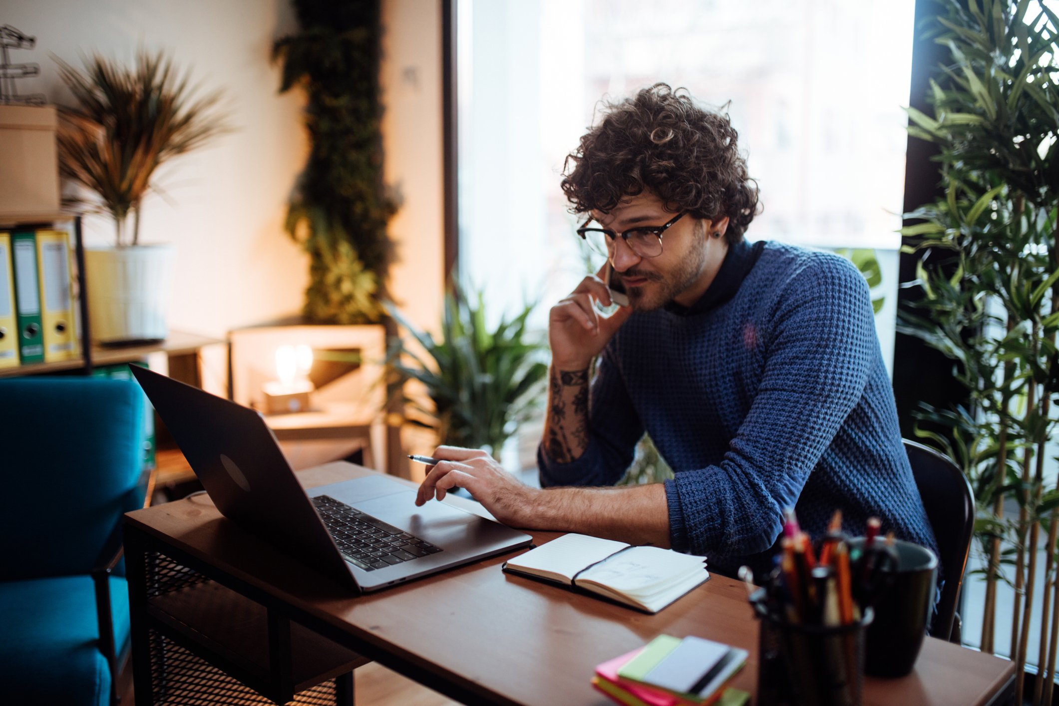 Man talking on phone in home office.