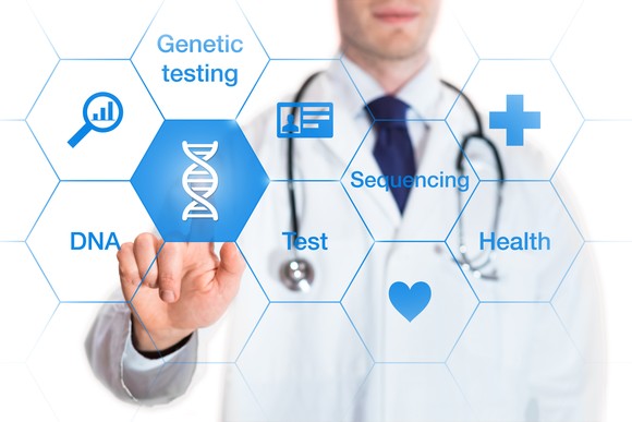 A physician pointing to an icon showing DNA next to other healthcare-related icons.
