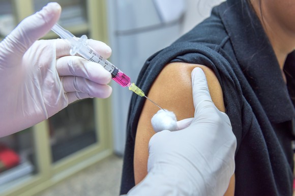 A close-up photo of a person receiving a shot in the arm.