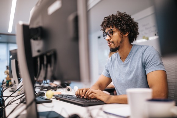 Person using laptop in a computer lab.