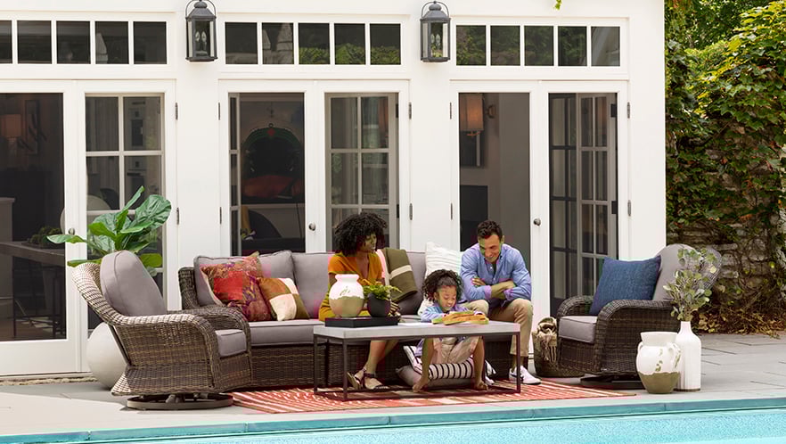 Family sitting on patio furniture.